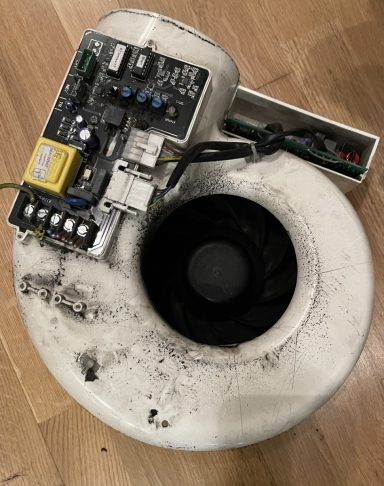 A weathered device with a circular fan and electronic components on top.